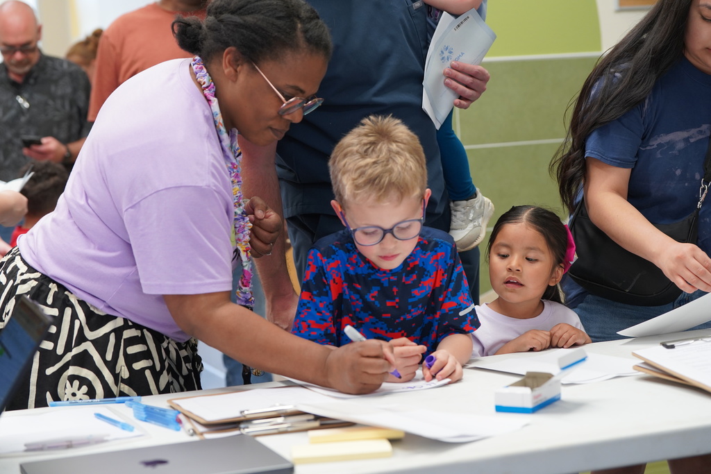 Principal helping student write name