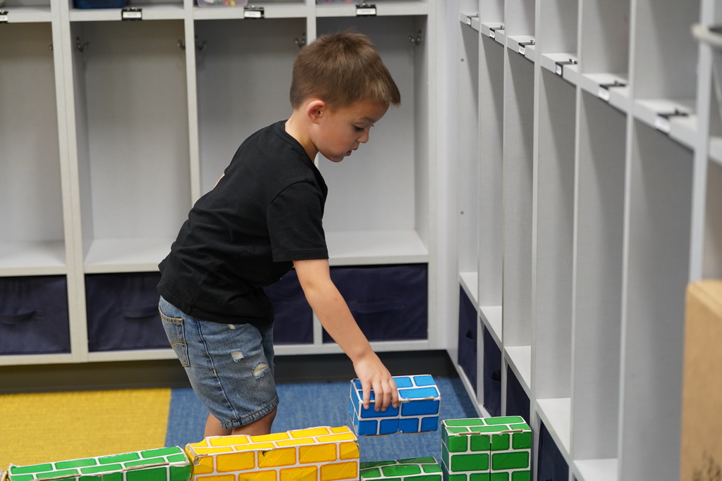Student building a wall with  bricks
