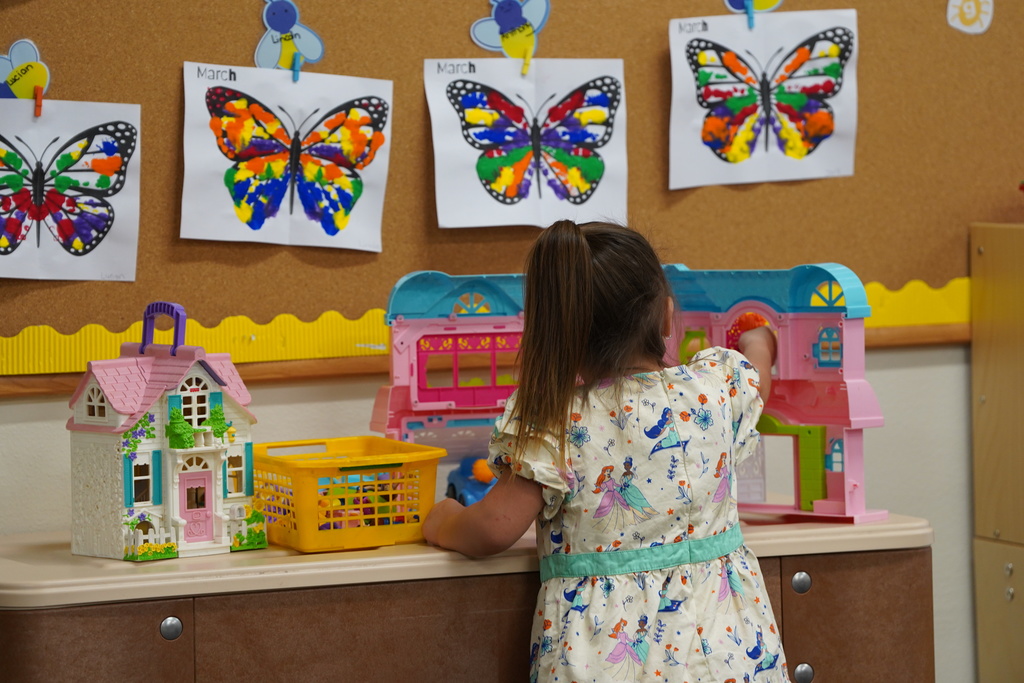 Student playing with dollhouse