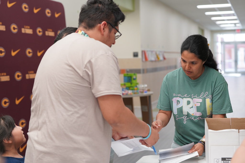Teacher helping enroll families at Nance