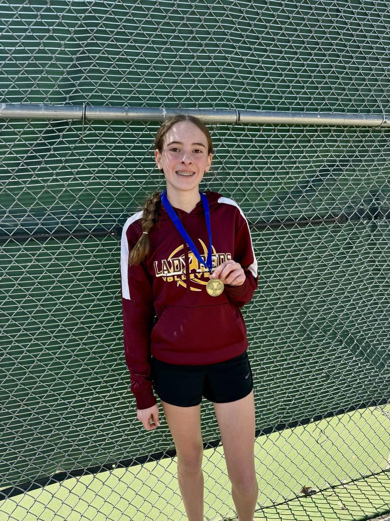 Tennis player holding 1st place medal