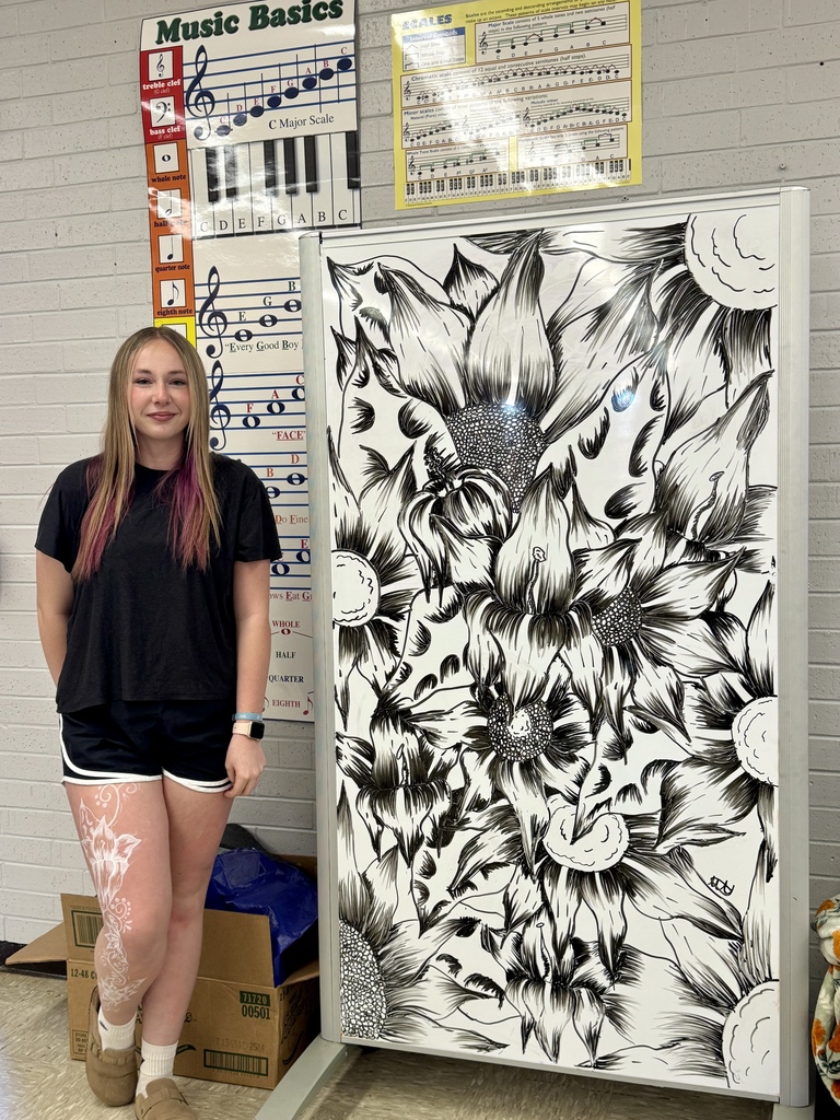 Student standing next to her whiteboard artwork.
