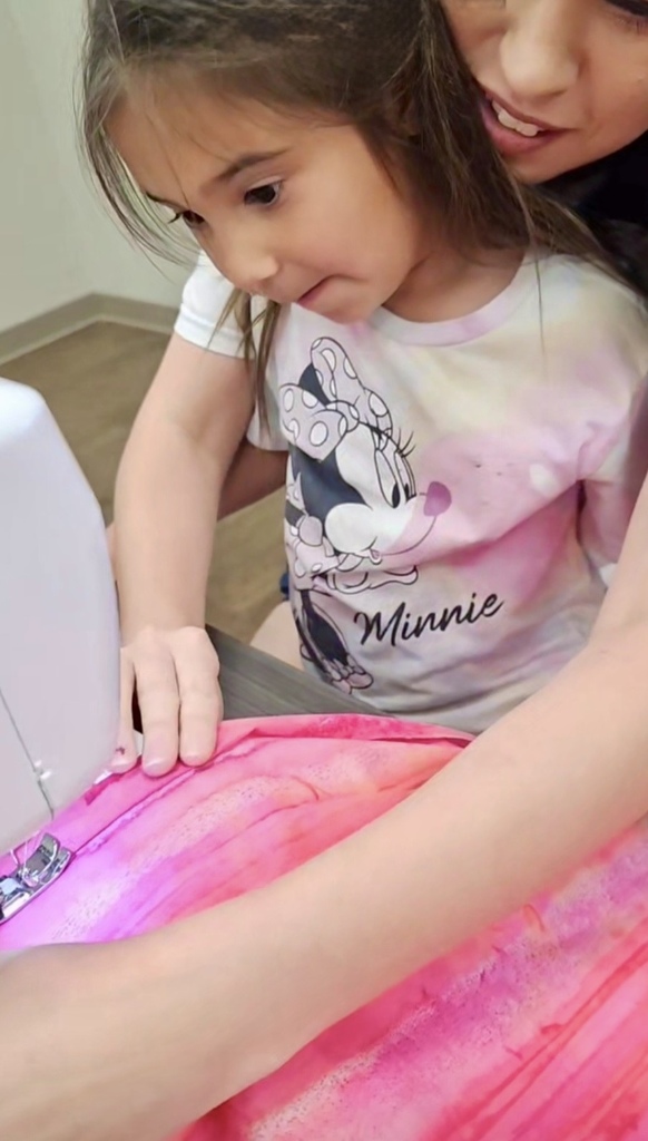Student with mom sewing a skirt