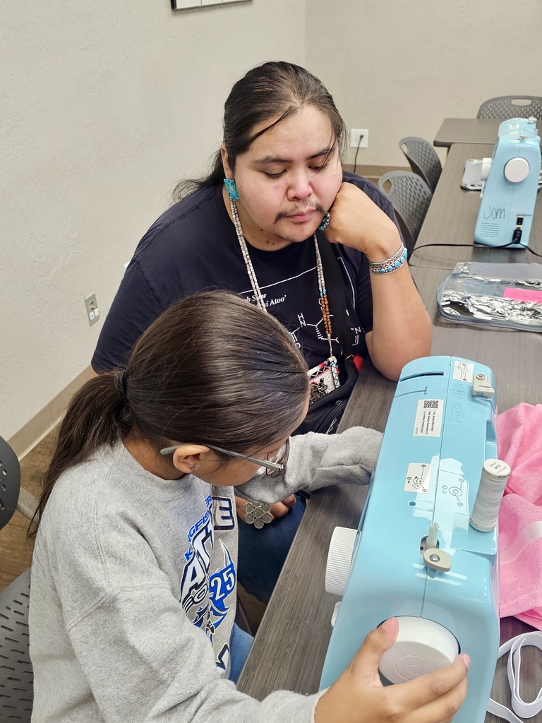 Sewing teacher helping student sew a skirt