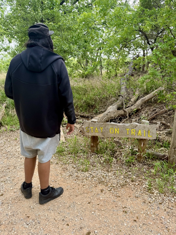 Student looking at stay on trail sign