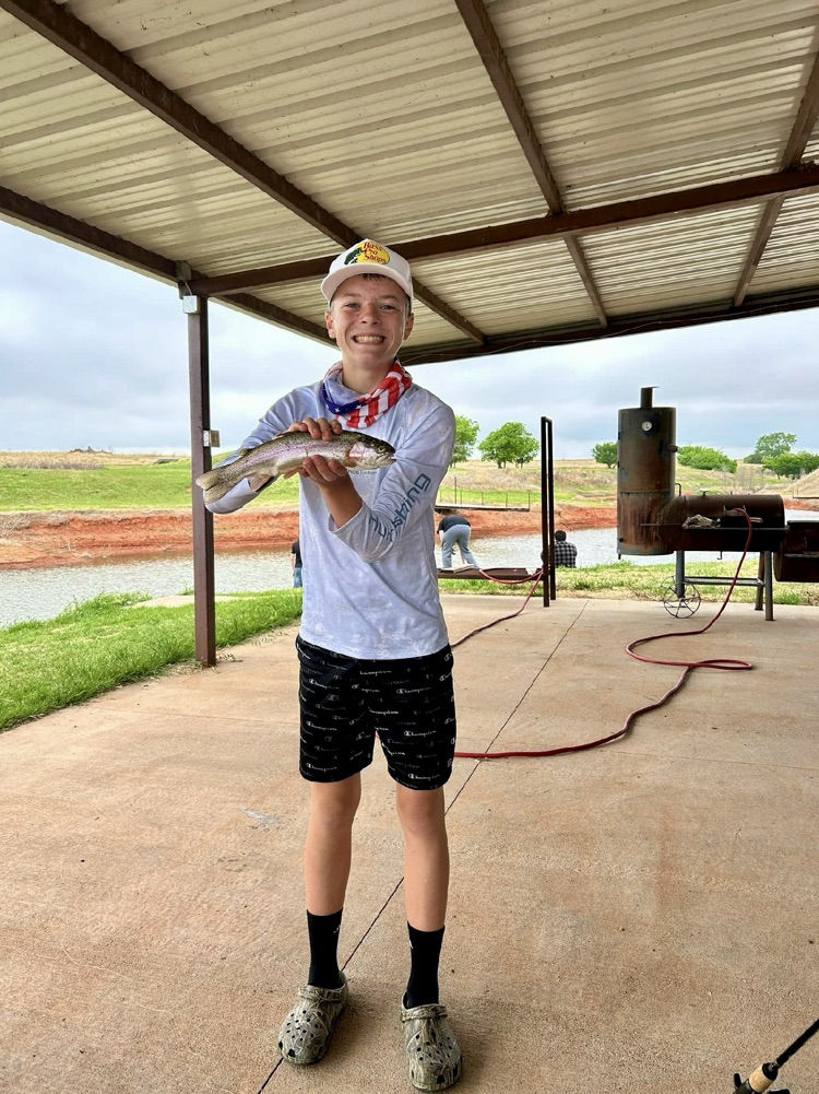 student standing and holding a fish 