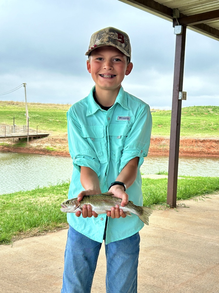 student standing and fish he caught
