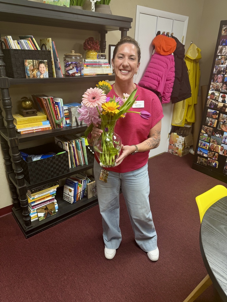 Principal holding vase of flowers