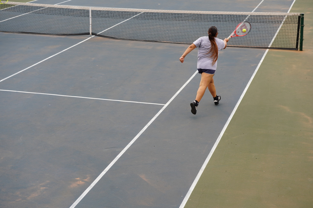 Lady Reds Tennis player going for the net shot