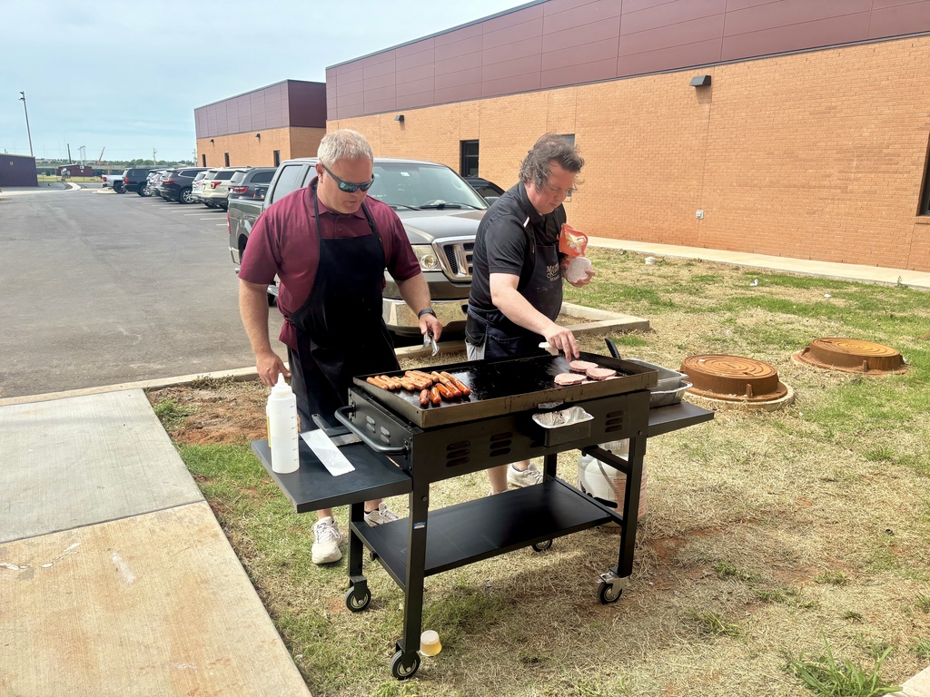 Mr. Ray and Mr. Wheeler grilling hamburgers and hot dogs