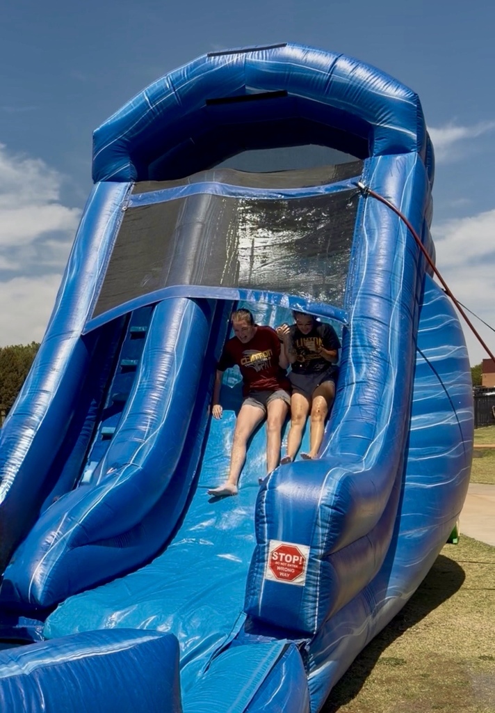 Students sliding side by side on waterslide at CMS Champions Party