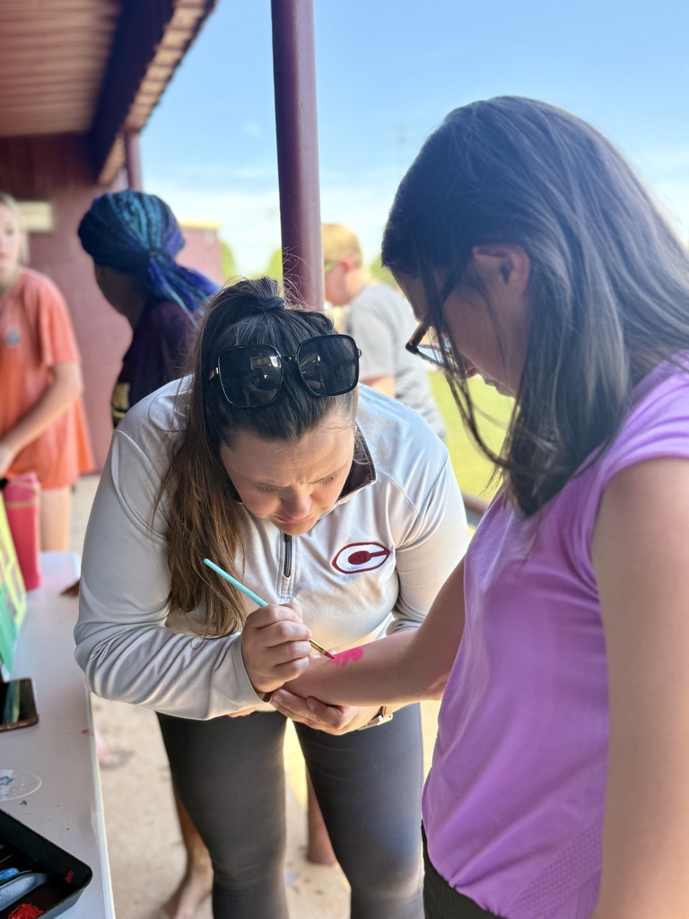 Teacher painting student's arm at CMS Champions Party