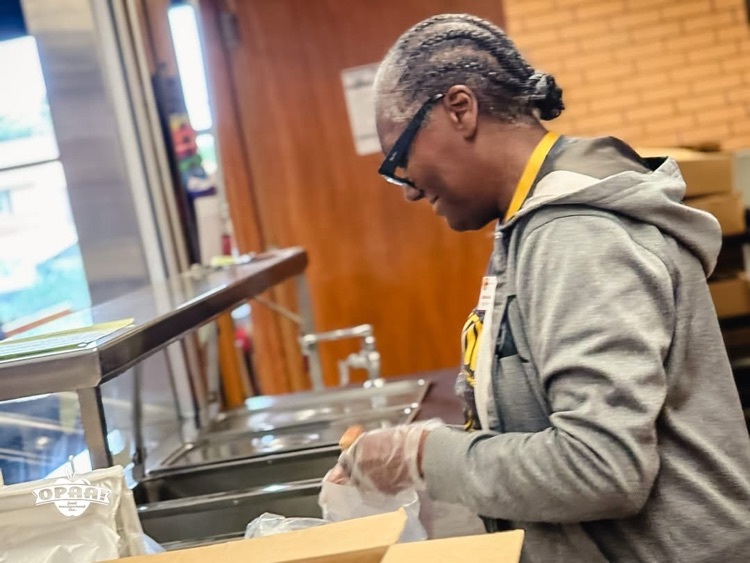 Cafeteria worker putting food in sandwich bag