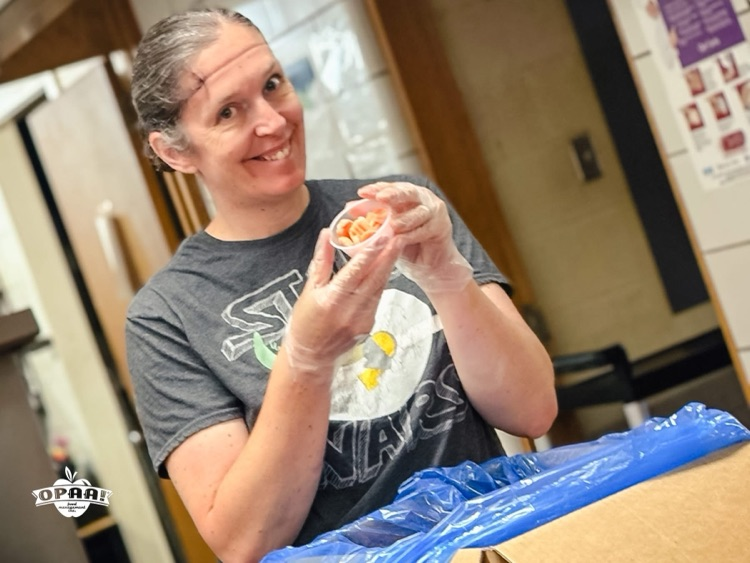 Cafeteria worker packing veggies for lunches