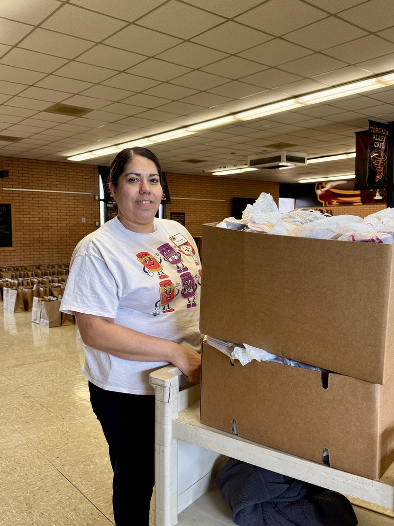 Cafeteria worker pushing cart of meals
