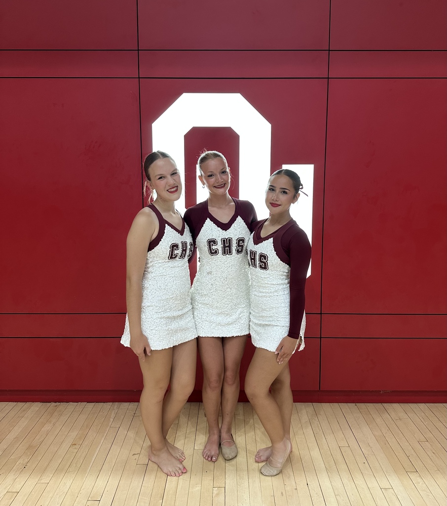 3 Pom Team members standing in front of OU logo