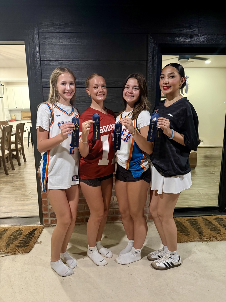 Pom Team members showing off their ribbons