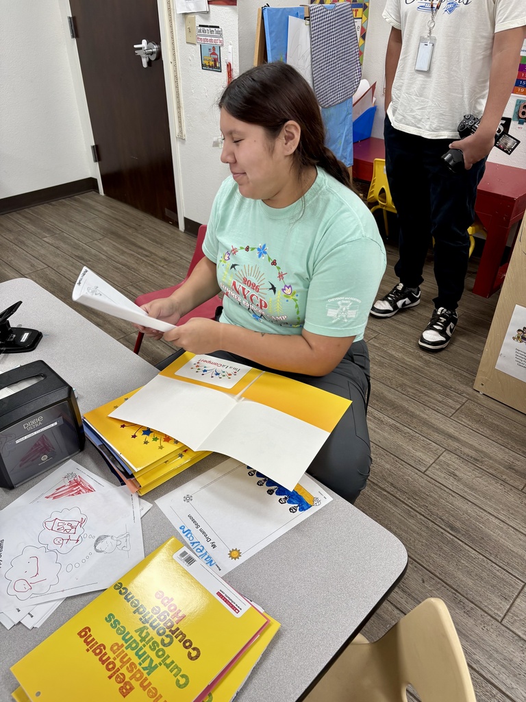 Female high school student filing papers in folder