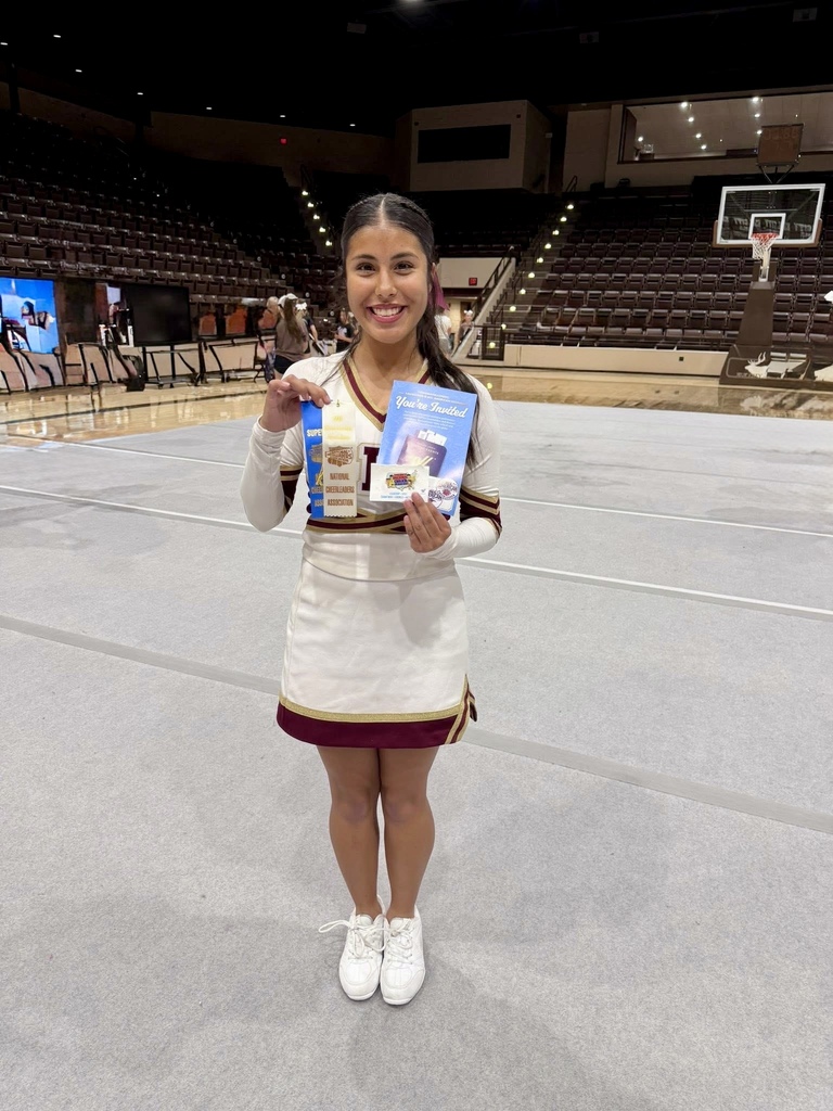Cheerleader smiling and holding her camp awards
