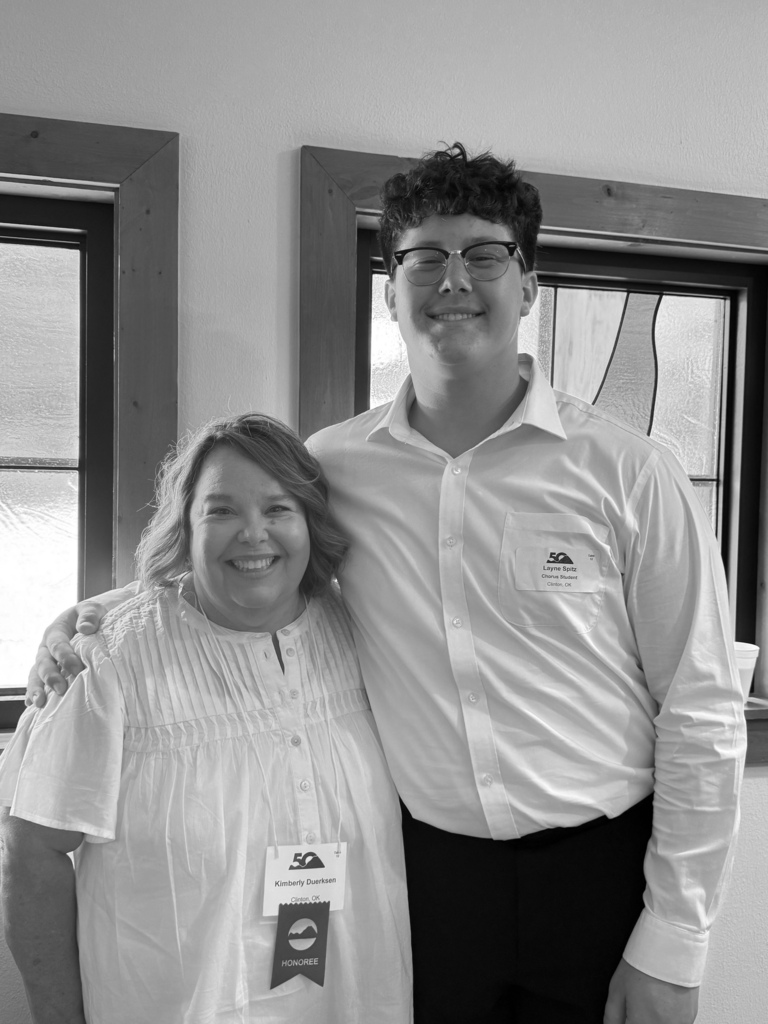 Choir teacher and student smiling in front of window