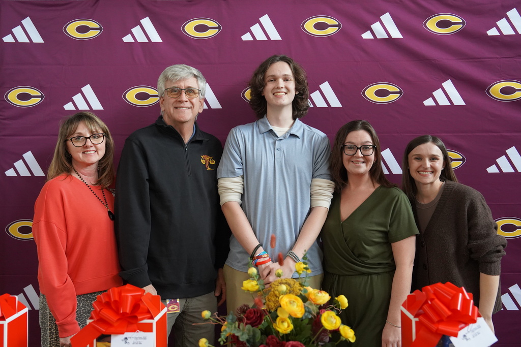 Student smiling standing next to his impactful teachers
