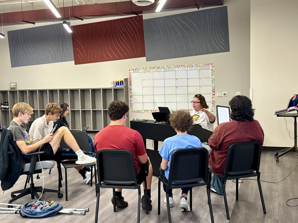 CHS Vocal Boys sitting around the piano
