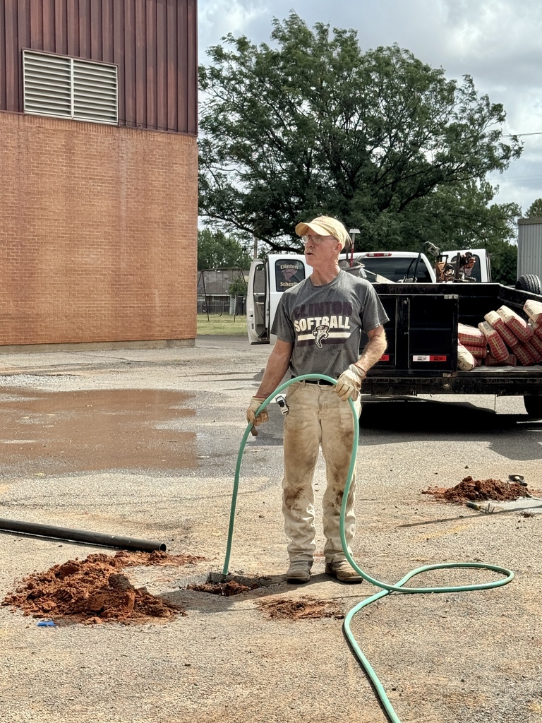 Maintenance worker filling post hole with water