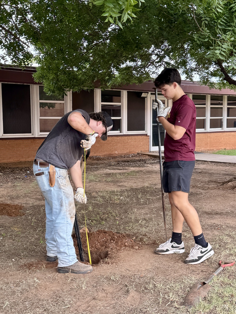Student workers measuring depth of hole