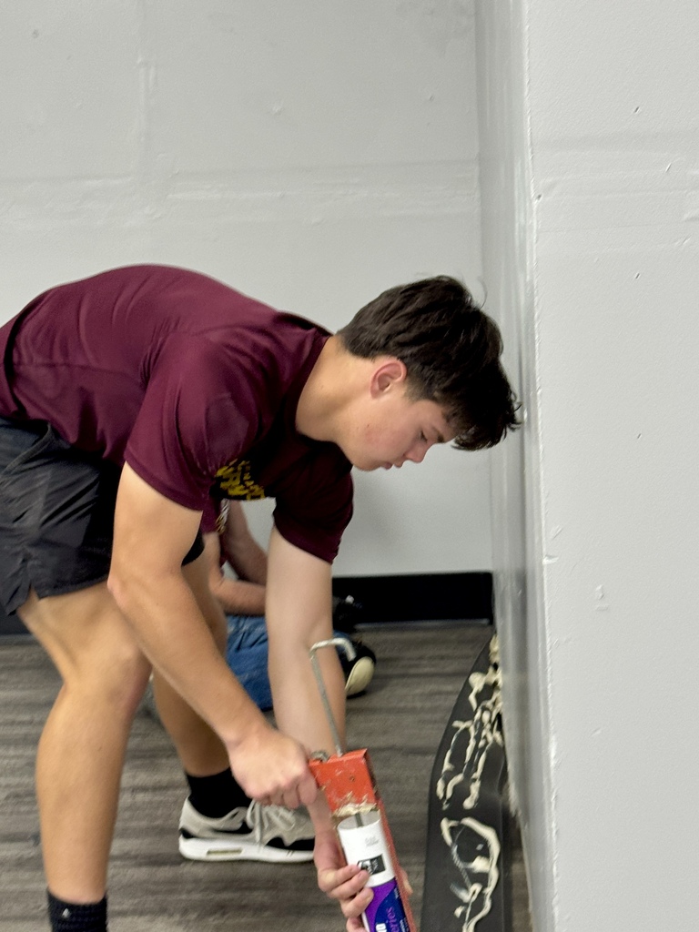 Student worker adding glue to trim