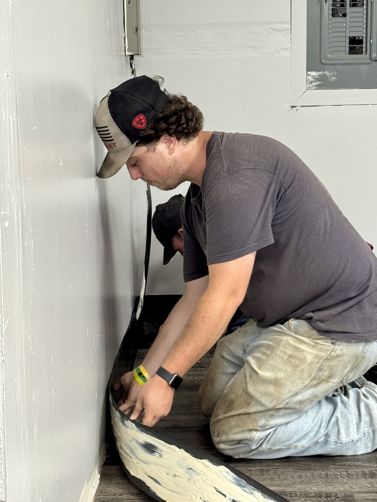 Student worker putting trim up in resource room