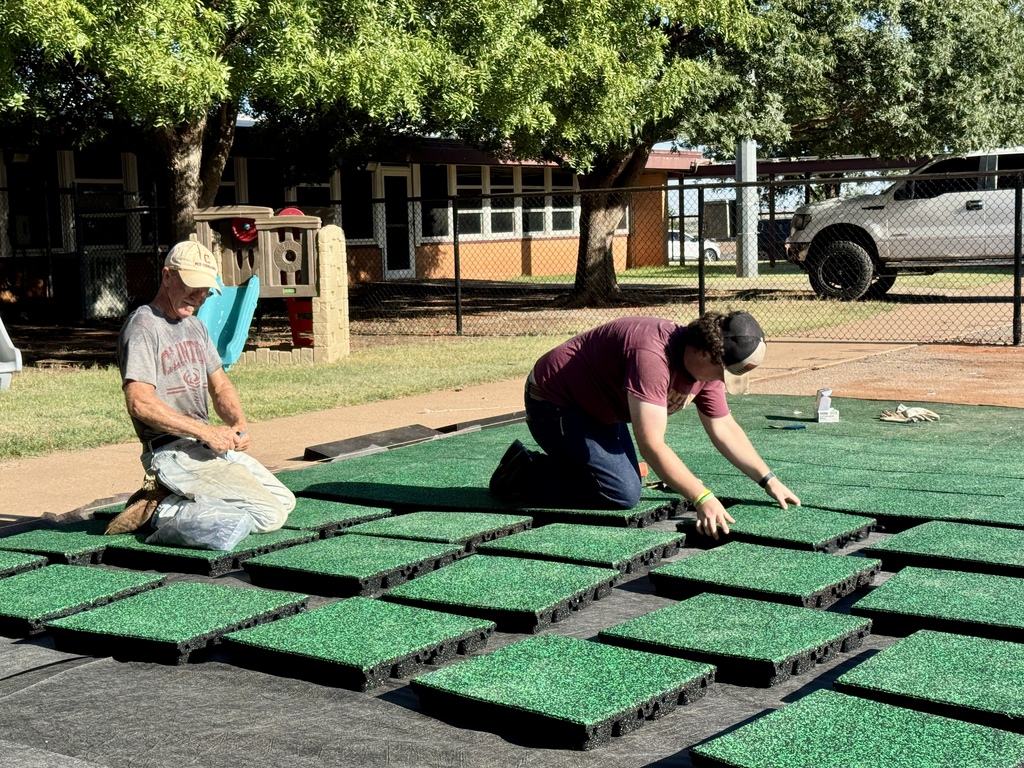 Workers installing playground flooring