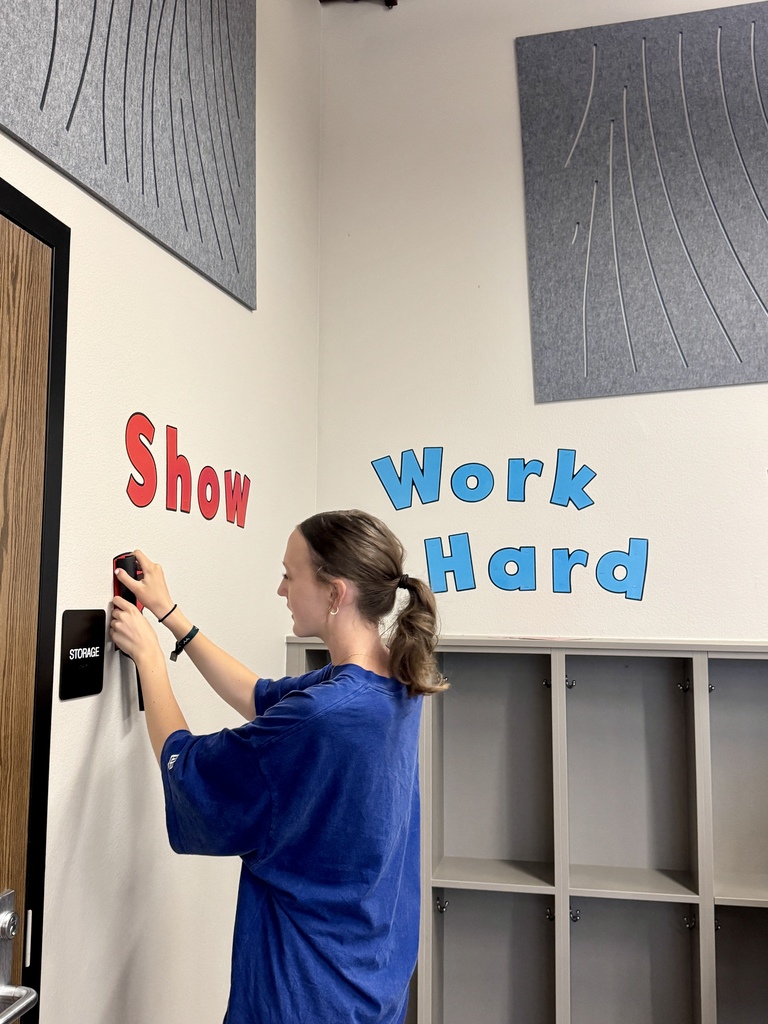 Student hanging positive words on the choir wall