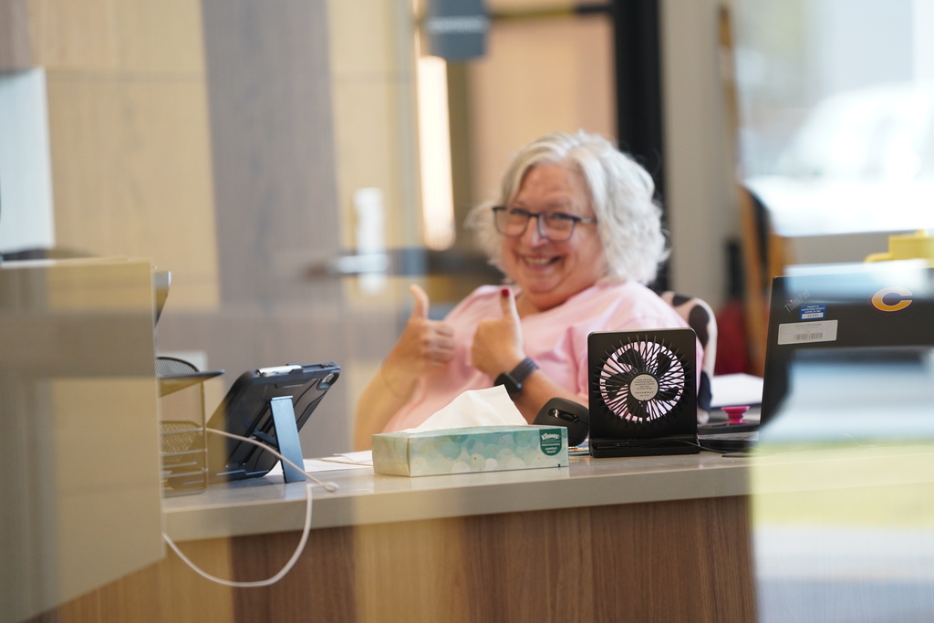 Teacher giving a thumbs up at desk