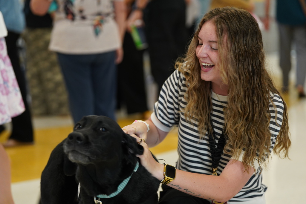 Teacher petting a service dog