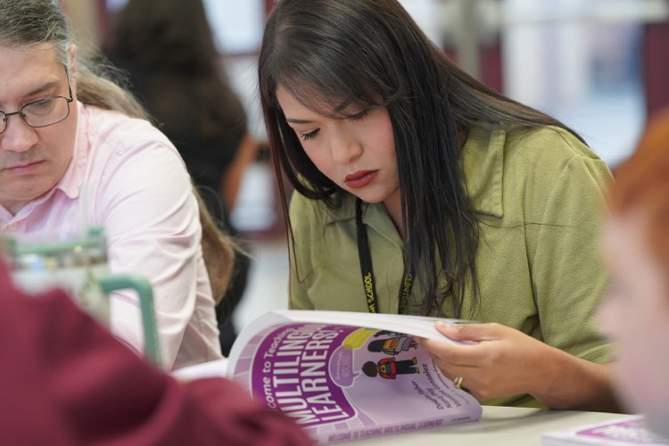 teacher looking at multilingual book
