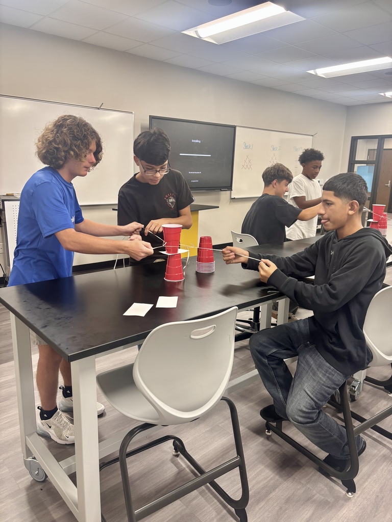 Students stacking cups and using rubber band pulleys