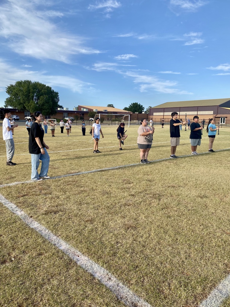 Band members standing at attention during rehearsal