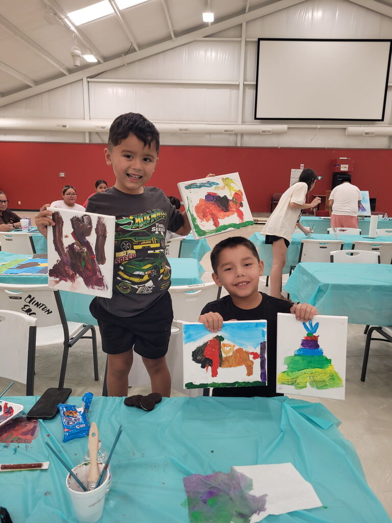 2 students holding artwork