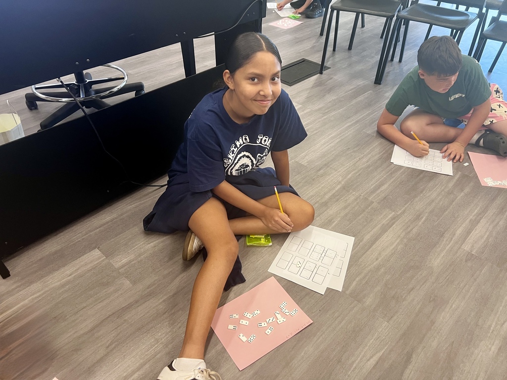 Student sitting on floor using dominoes to create patterns in music class