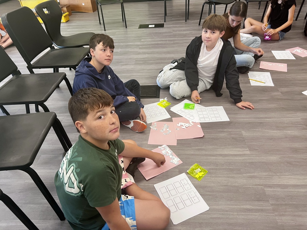 3 students creating patterns with dominoes in music class