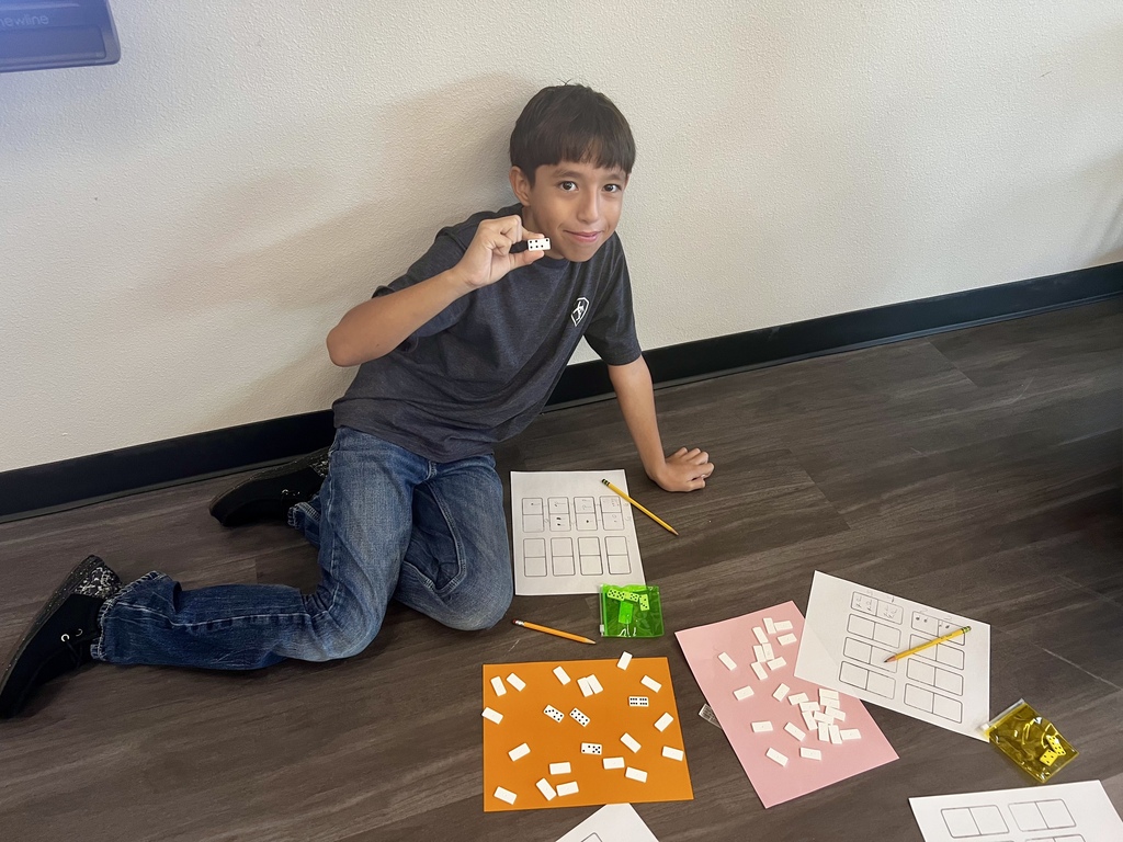 Student holding up domino while working on rythms in music