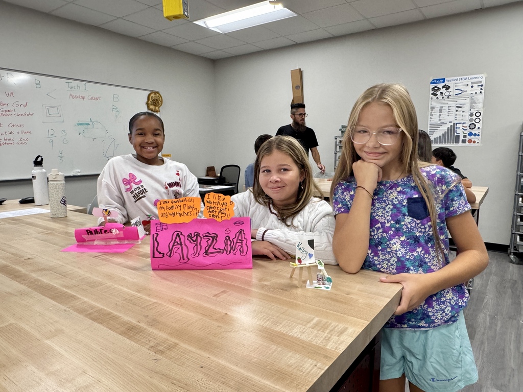 3 students showing off their name plates