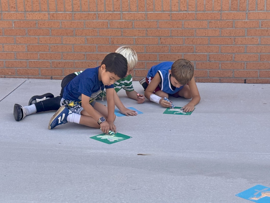 3 Nance students working hard on their sidewalk chalk drawing