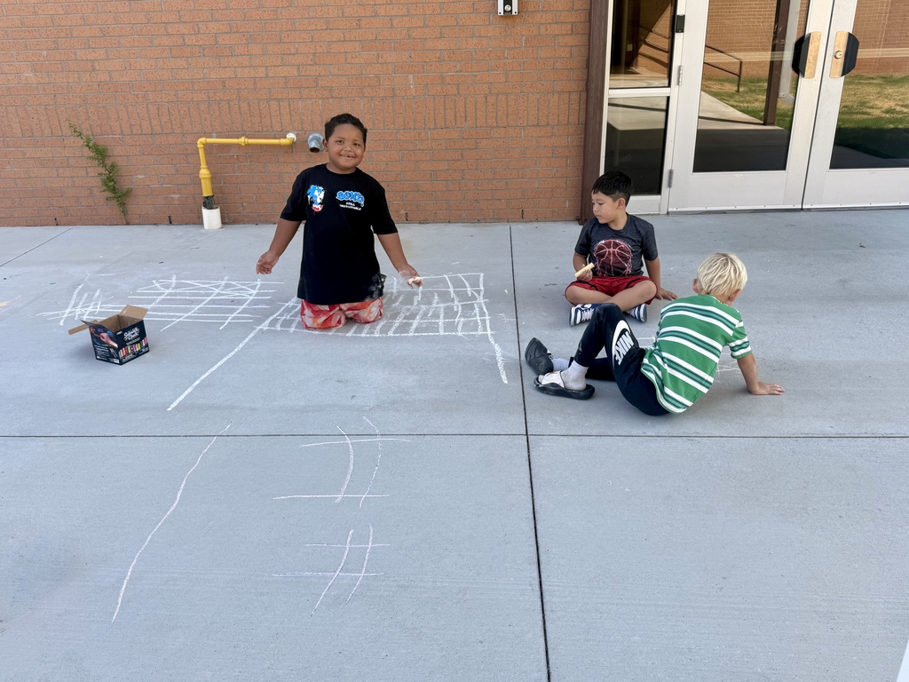 3 Nance students drawing with chalk on sidewalk