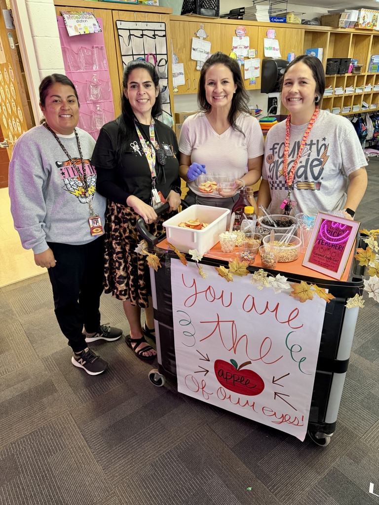 3 teachers and the counselor smiling in front of the apple cart