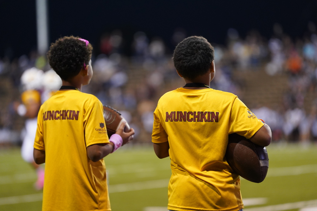 Munchkin managers holding footballs and watching the game