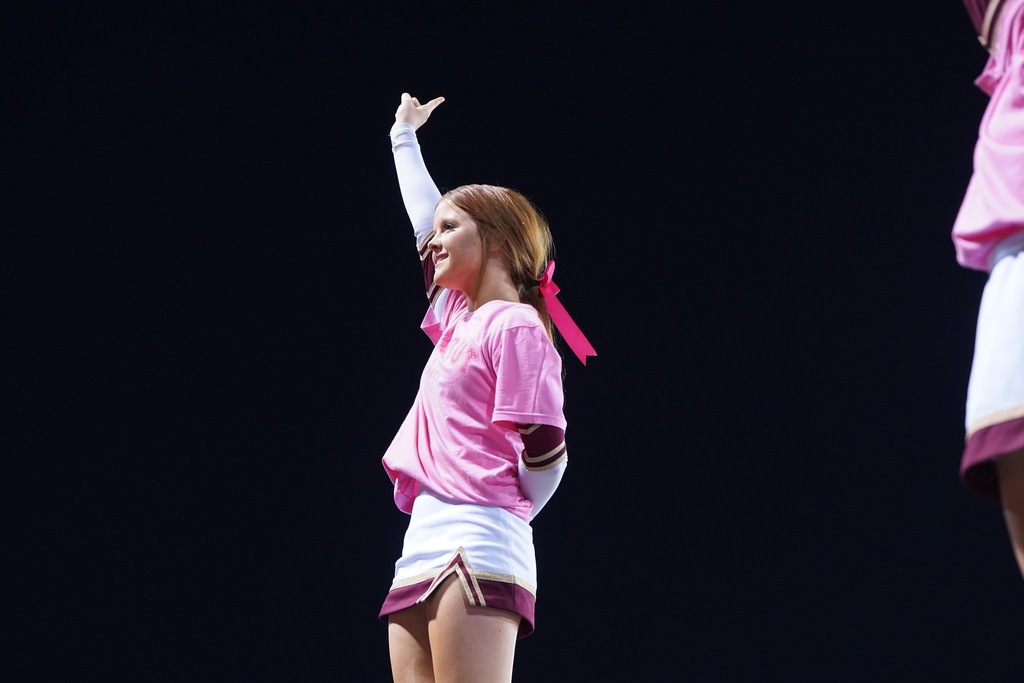 Cheerleader on top of pyramid holding up a number one 