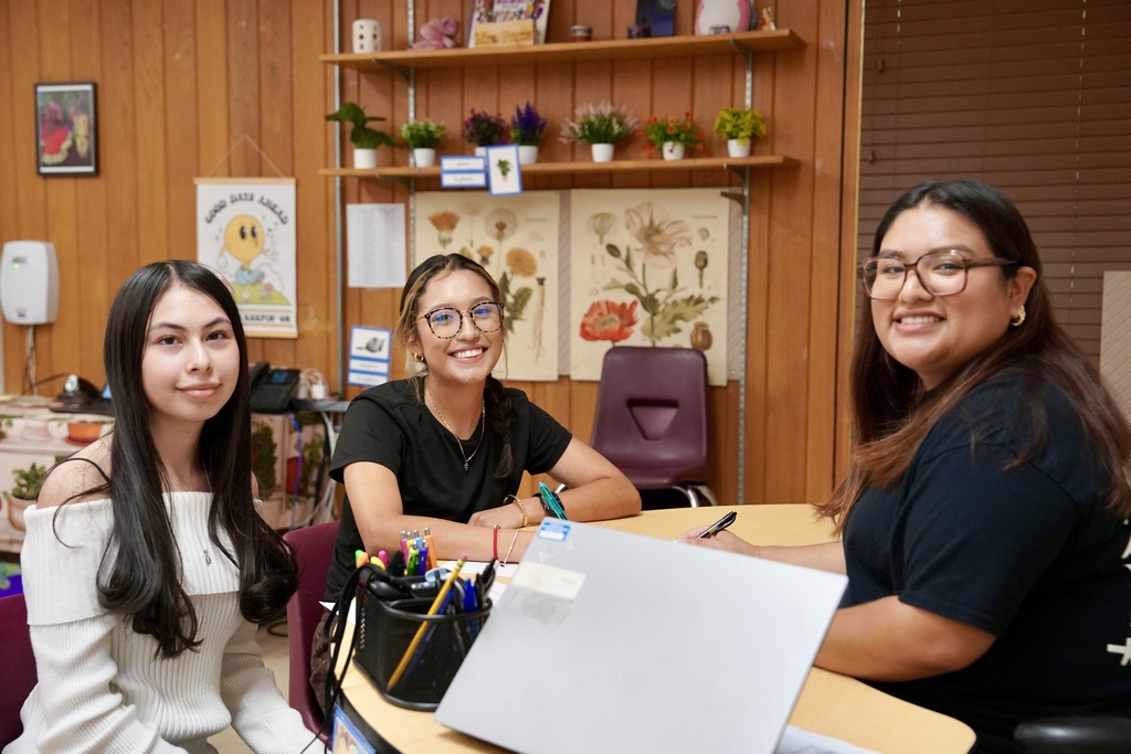 Multilingual assistant working with 2 students at CHS
