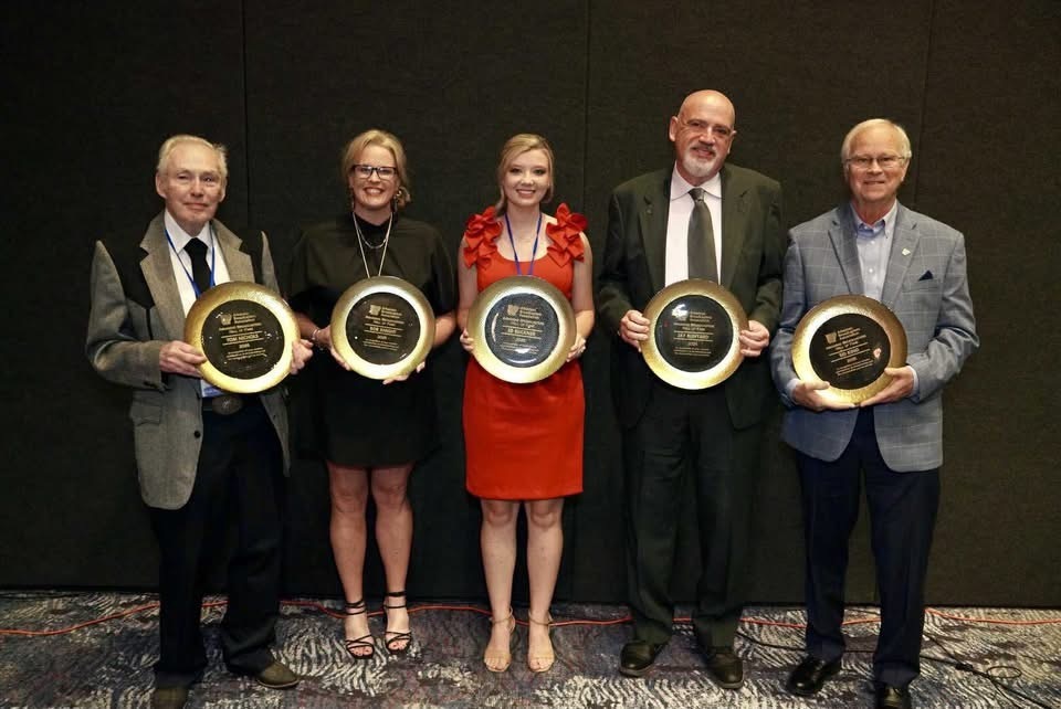 group of adults holding awards