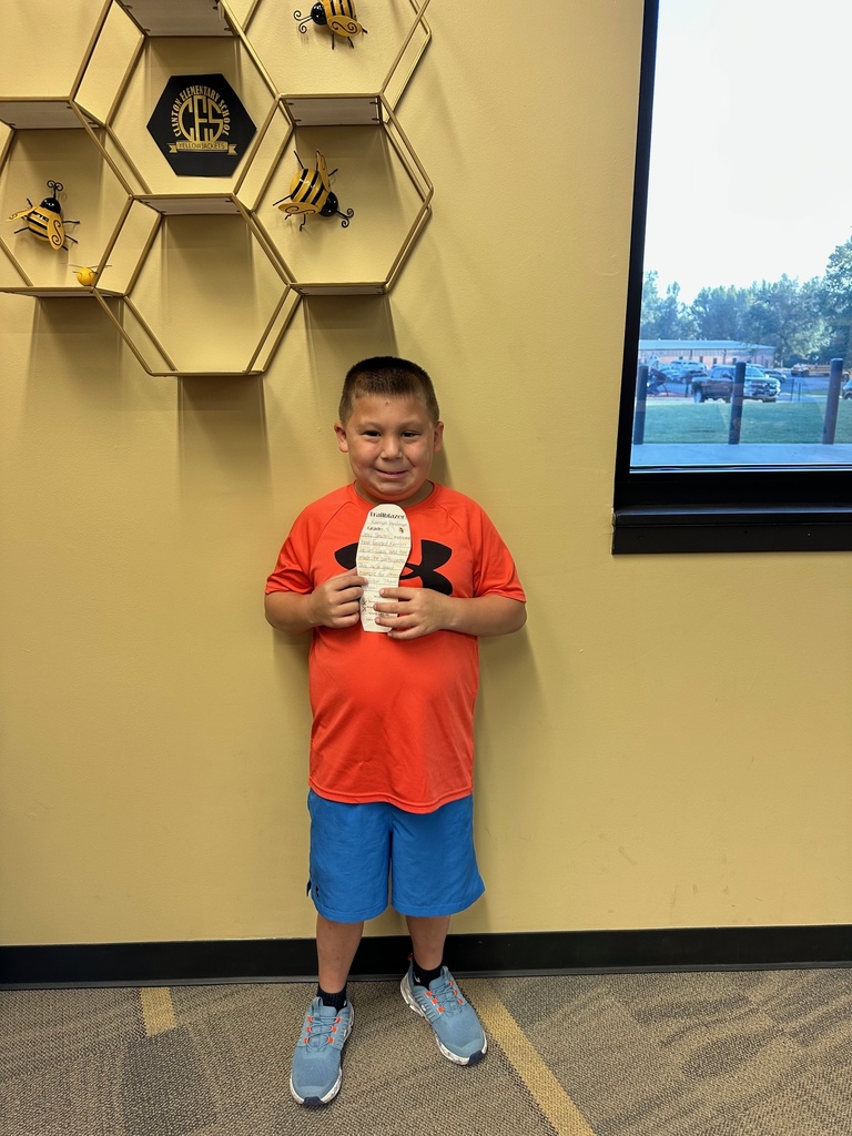 boy holding a paper foot